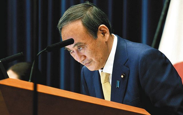 記者会見で頭を下げる菅首相