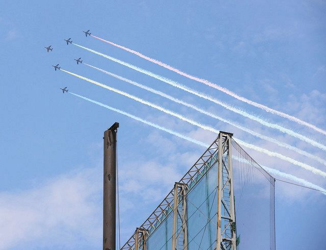 ５色のカラースモークを出して神宮球場の上空を飛行する航空自衛隊の「ブルーインパルス」