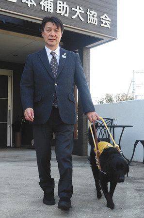 盲導犬とともに聖火リレーの出番を待つ青木さん＝横浜市旭区で