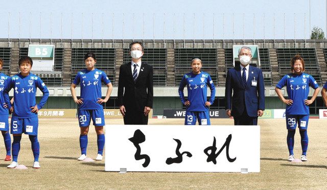 記念撮影する富岡市長（右から２人目）と女子プロサッカーチーム「エルフェン」の選手ら＝熊谷市の熊谷スポーツ文化公園陸上競技場で
