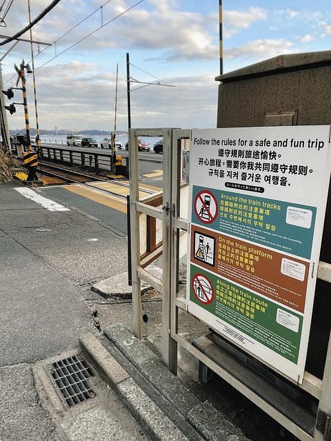 踏切には英語と中国語、韓国語でルール順守を呼びかける看板が設置されている