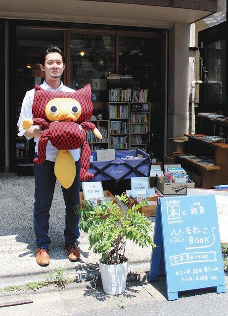 不忍ブックストリートの公式キャラクター「しのばずくん」のぬいぐるみを抱える書店「ひるねこＢＯＯＫＳ」店主の小張隆さん＝台東区で