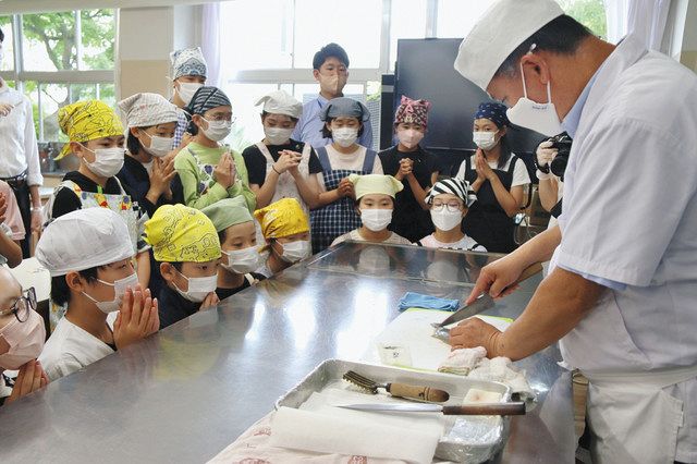 斉藤さん（右）がヒラメをおろす様子を見る子どもたち＝足立区提供