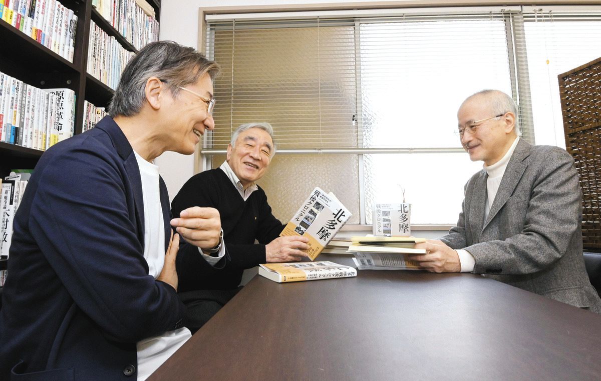 でき上がったばかりの本を手に取る（左から）片岡義博さん、飯岡志郎さん、杉山尚次さん＝東京都千代田区で