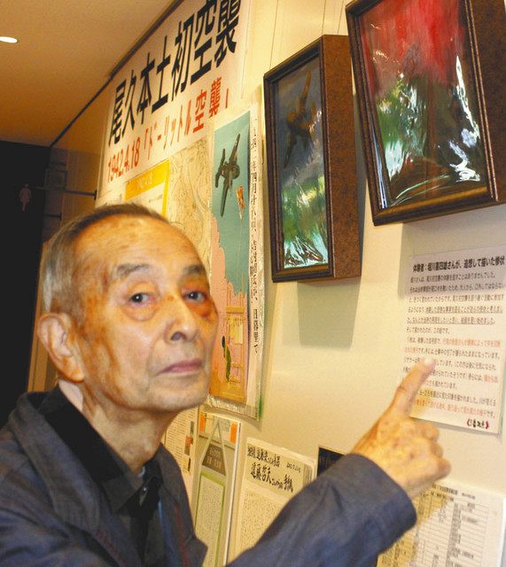 自ら描いた空襲の絵の前に立つ堀川さん＝東京都荒川区で
