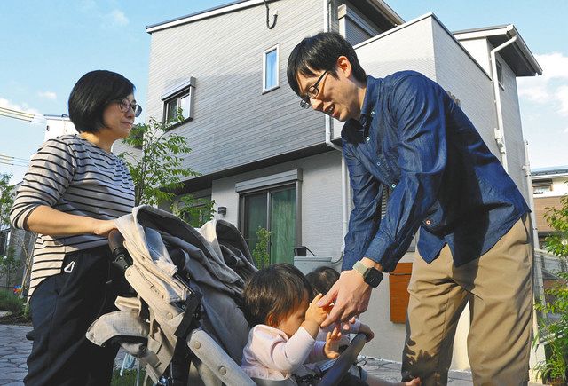 自宅前で子どもをあやす大橋健人さん（右）と妻の美由樹さん＝いずれもさいたま市緑区で