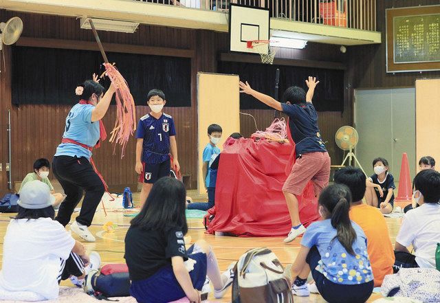赤い布と跳び箱で作ったキャンプファイアを囲む児童たち＝東京都新宿区の区立落合第6小で