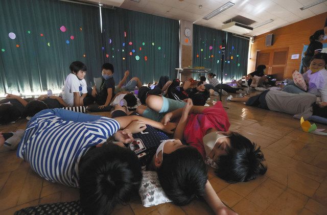 女神湖の星空に見立てた「プラネタリウム」を眺める児童たち。枕はそれぞれが手作りした＝東京都新宿区の区立落合第6小で