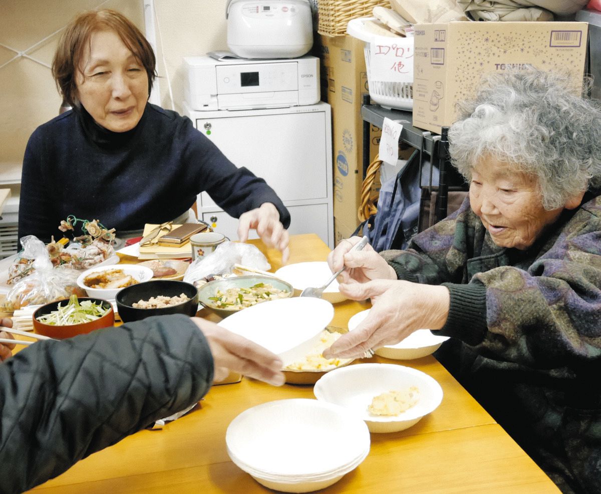 子ども食堂でおかずを取り分けるばあちゃん（右）と橋本弥寿子さん＝東京都北区で