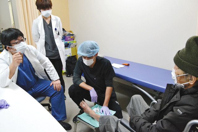 患者（右端）を形成外科医（中央）らと診察する毛利晋輔医師（左端）＝横浜市鶴見区で