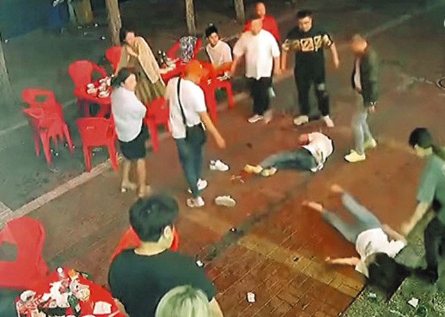 10日未明、中国河北省唐山市の串焼き店の外で、暴行されて路上に倒れ込む女性ら＝微博から 
