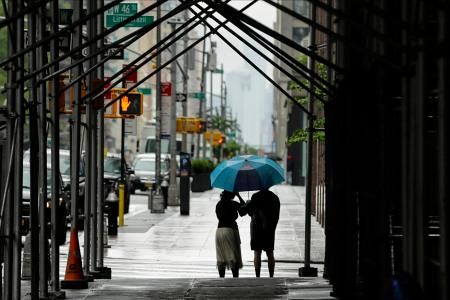 　傘を差して歩く人々＝２３日、ニューヨーク（ＡＰ＝共同）