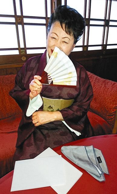 扇子などを使った感染予防策を説明する村上さん＝名古屋市中区で