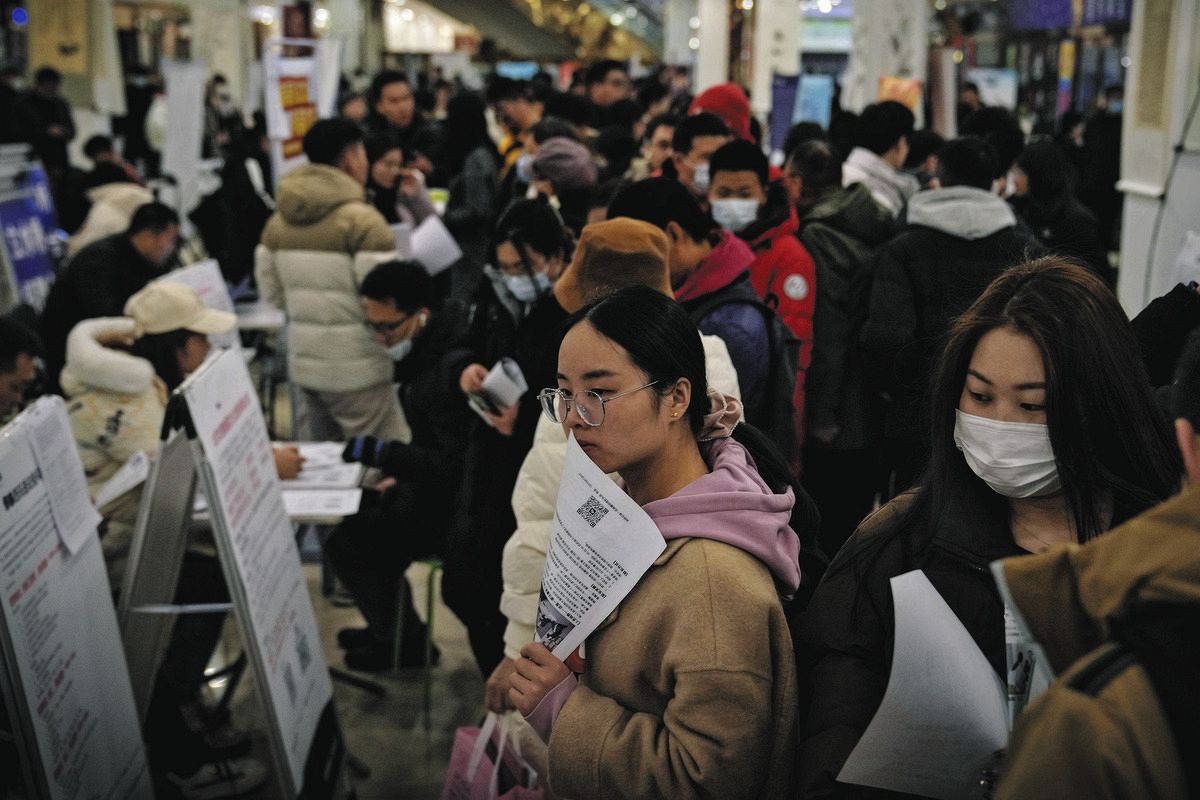 2月、北京で開かれた就職フェアで、求人情報を探す人たち（AP）