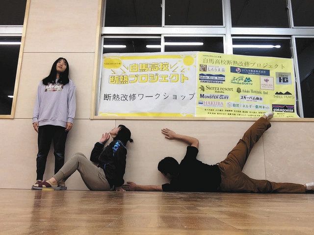 昨年９月、断熱改修完了のうれしさで壁に張り付く宮坂さん（左）、金子さん（中）、手塚さん（提供写真）