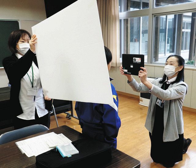 小学校に出向き、児童のマイナンバーカード申請用の写真を撮る富山県朝日町の職員。各地で国主導のカード交付率競争が起きた＝2022年12月、同町で
