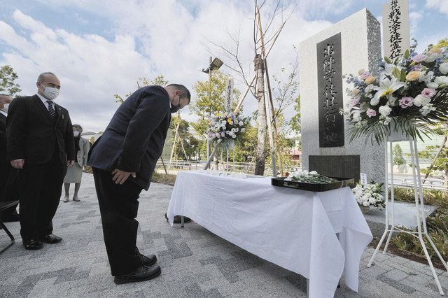 「出陣学徒壮行の地」の碑に供花し、一礼する参加者＝２１日、東京都新宿区の国立競技場で