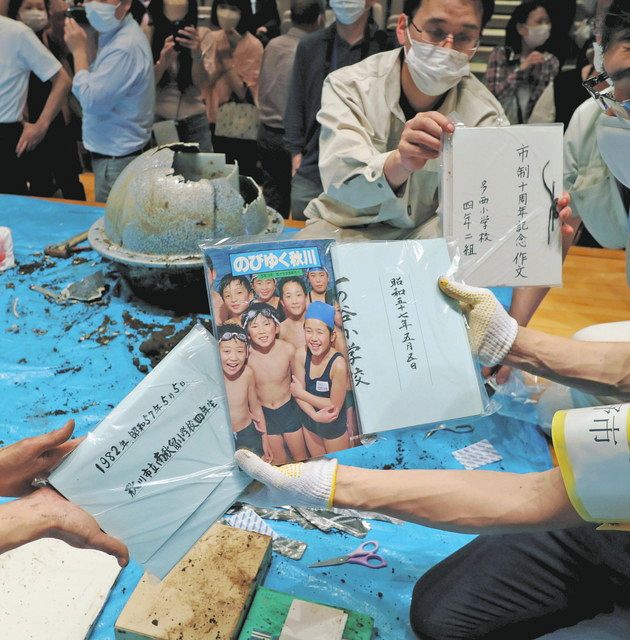 ﻿タイムカプセル（左上）から取り出された小学4年生の作文などの記念品＝東京都あきる野市で
