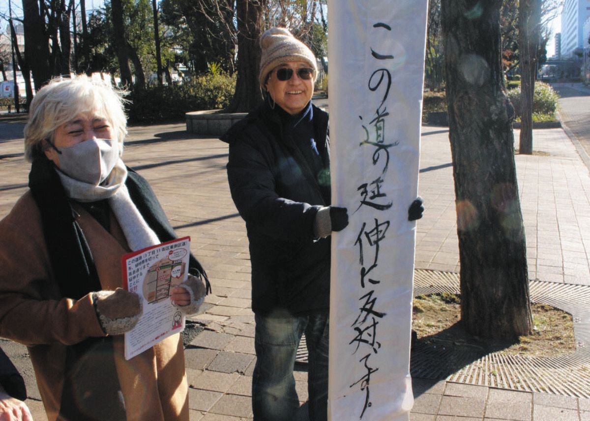 看板を掲げて高島平緑地に立つ山名泉さんとチラシを持つ悦子さん