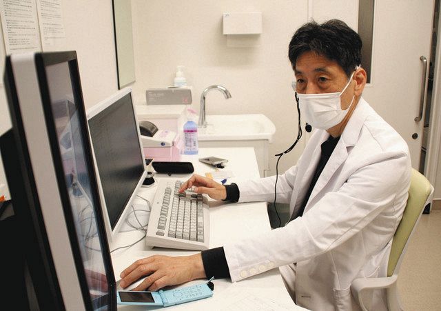 パソコンを見ながら自宅療養者に電話をかける立川医師＝横浜市立市民病院で