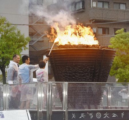 約６０年ぶりに製造された埼玉県川口市に戻り、子どもたちによって点火された聖火台。左端は室伏広治さん＝６日午前