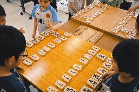 特大の将棋盤で対局の準備をする子どもたち。中央が通常の将棋盤＝太田市で
