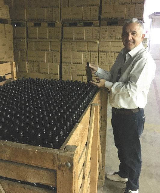 １０月下旬、エジプト東部エルグーナで、瓶詰めが終わったワインを手にする「エジビブ」のカラス工場長
