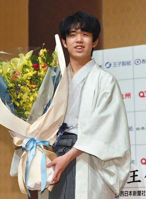 史上最年少での二冠と八段昇段を達成。花束を手に笑顔の藤井聡太新王位＝２０日、福岡市内のホテルで