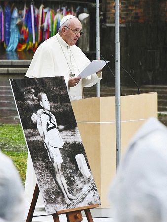 「焼き場に立つ少年」のパネル写真を傍らに置き、演説で核廃絶の必要性を訴えるローマ教皇フランシスコ＝２４日、長崎市の爆心地公園で