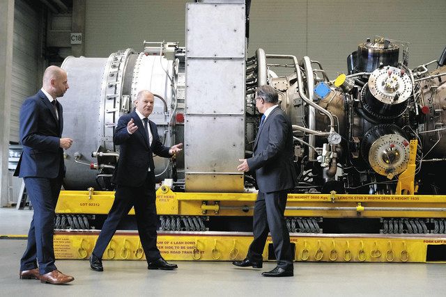 ロシアとドイツを結ぶ天然ガスパイプライン「ノルドストリーム」に使われるタービンを視察するドイツのショルツ首相（中央）＝dpa・AP