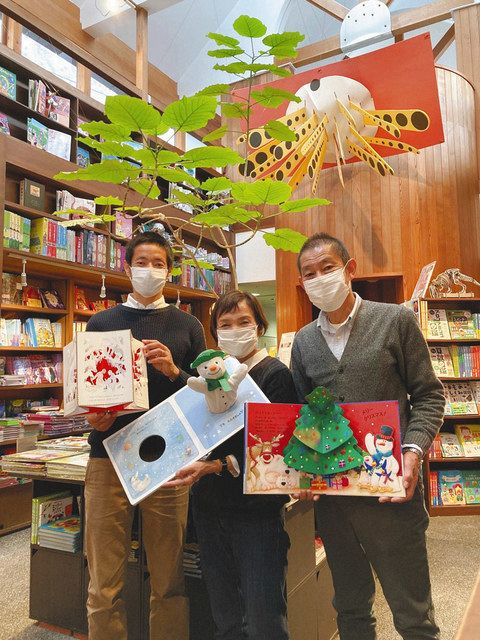 右から嵐田康平さん、晴代さん、一平さん。３人が持っているのは、クリスマス向けのしかけ絵本
