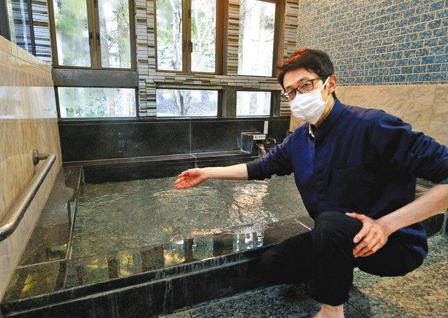 鉱泉を沸かしたお湯の温度を確かめる小林康昭さん＝常陸太田市で
