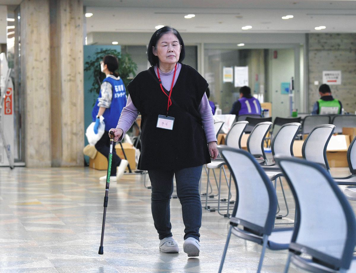 輪島から金沢に避難。杖を手に避難所内を歩く谷律子さん＝2月25日、金沢市稚日野町北のいしかわ総合スポーツセンターで