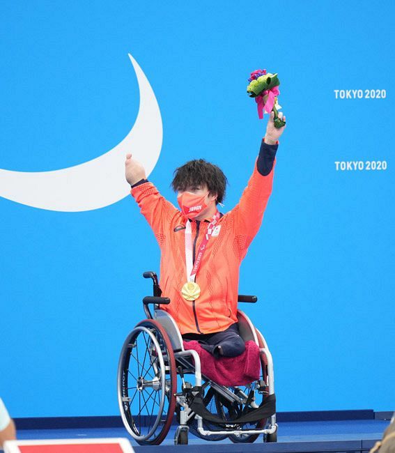 金メダルを獲得し、表彰式でブーケを掲げる鈴木孝幸