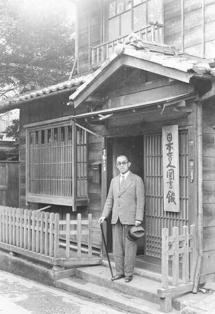 豊島区雑司が谷にあった日本盲人図書館前に立つ本間一夫（日本点字図書館提供）
