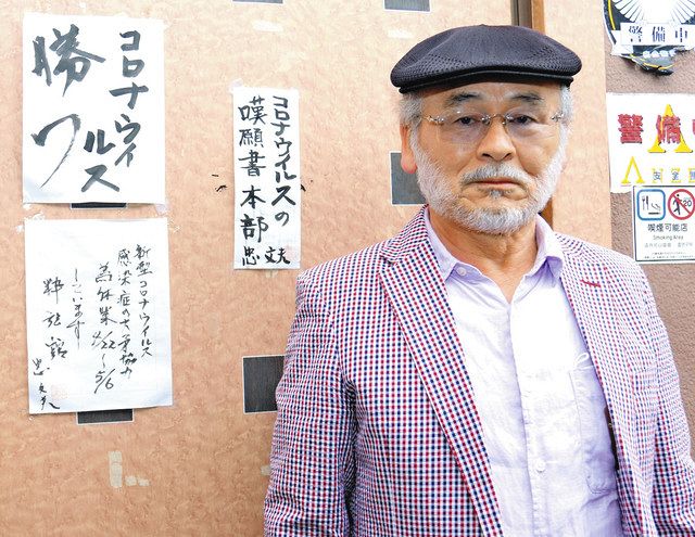 「コロナウイルスの嘆願書本部」などの張り紙をした店の前に立つ忠文夫さん＝水戸市で 