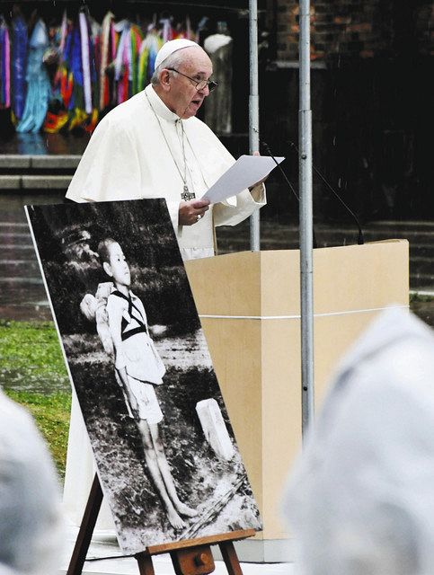 「焼き場に立つ少年」のパネル写真を傍らに置き、演説で核廃絶の必要性を訴えるローマ教皇フランシスコ＝昨年１１月、長崎市で
