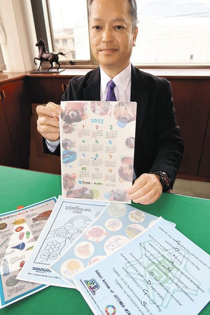 さまざまな印刷が施された紙のクリアファイルを手にする久保田基之さん＝静岡県富士市の東伸紙工で 