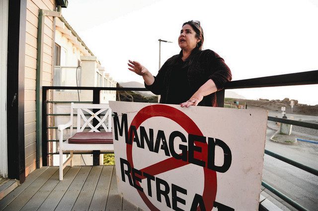 米カリフォルニア州パシフィカ市の自宅で、管理退去に反対する看板を手に語るスザンヌ・ドレイクさん