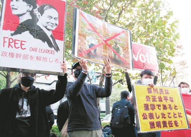 日本財団前でのデモで、笹川会長と国軍総司令官の会談写真に×印を付け、融和的な姿勢をとらないよう求めるミャンマー人ら＝東京都港区
