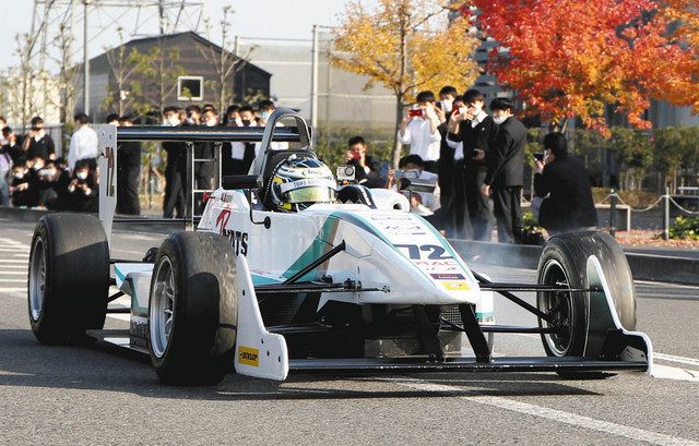 生徒たちが見守る公道でエンジン音を響かせるレーシングカー＝宇都宮市で 