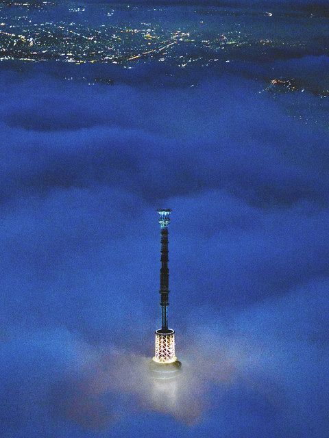 【雲】　雨上がりに低く垂れ込めた雲から白く光る塔頂部をのぞかせる＝２０１４年８月撮影、墨田区で、本社ヘリ「あさづる」から
