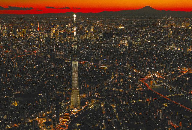 【赤焼けの富士】　赤く染まった夕焼けに浮かぶ富士山のシルエットとスカイツリー＝２０２１年２月撮影、墨田区で、本社ヘリ「おおづる」から
