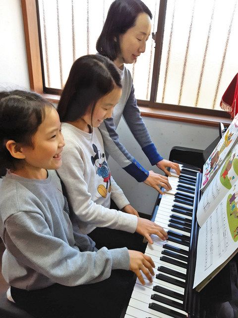 水害に遭い、修復したピアノを弾く鈴木智子さんと娘たち＝福島県いわき市で（鈴木智子さん提供）
