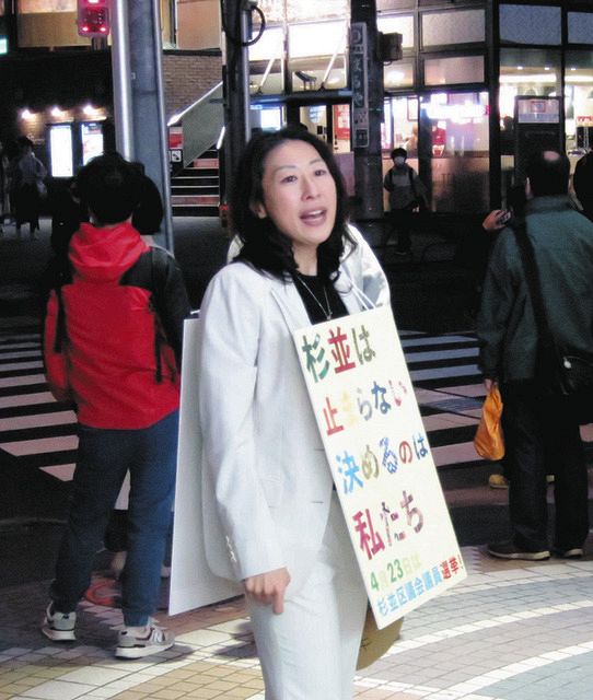 街頭に1人で立ち、東京都杉並区議選への投票を呼びかける岸本聡子さん（中）＝5日、同区で