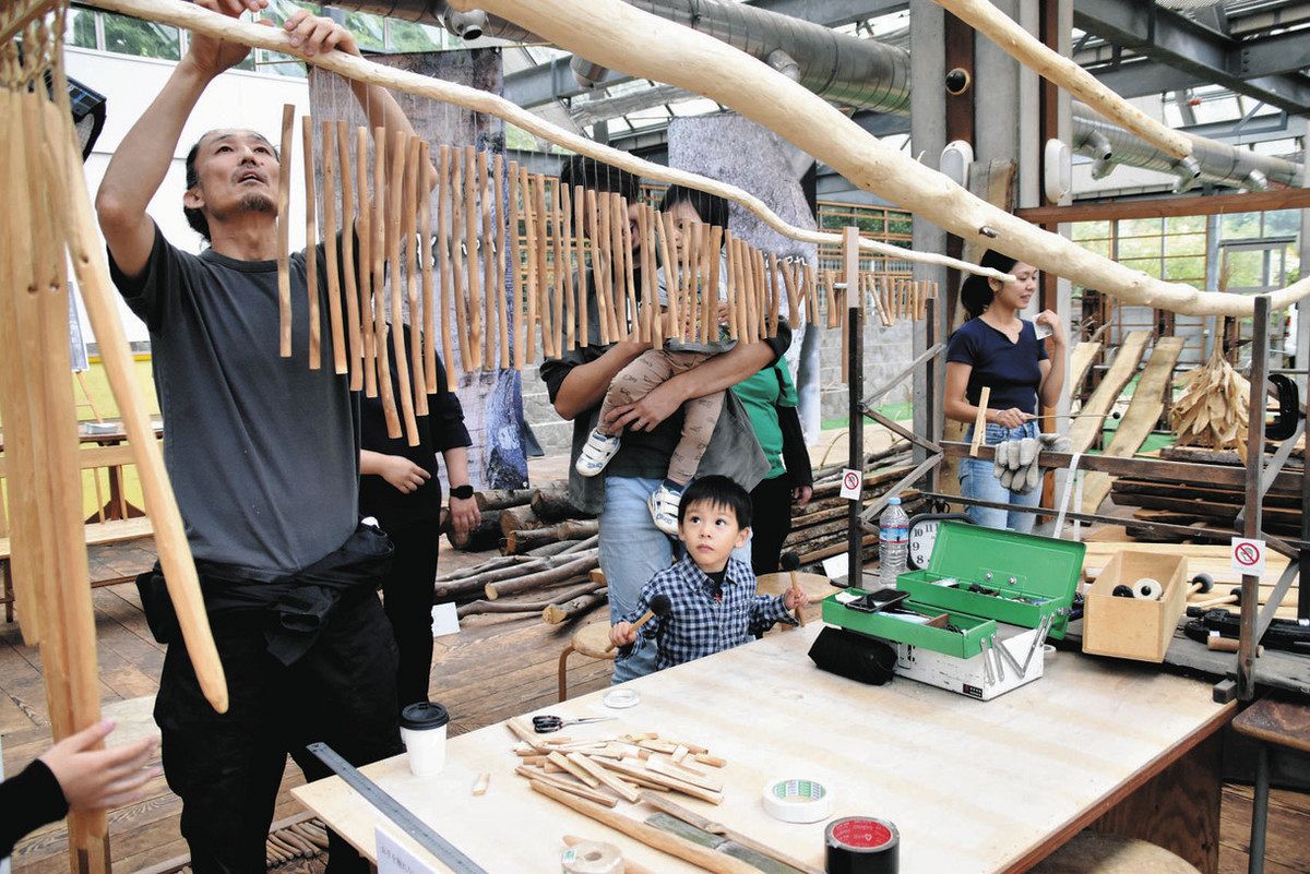 楽器を作る永井さん（左）と、音を楽しむ親子連れら 