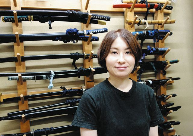 小道具担当の佐藤未紗さん。小道具部屋の壁には人形用の刀がぎっしりかけられている 