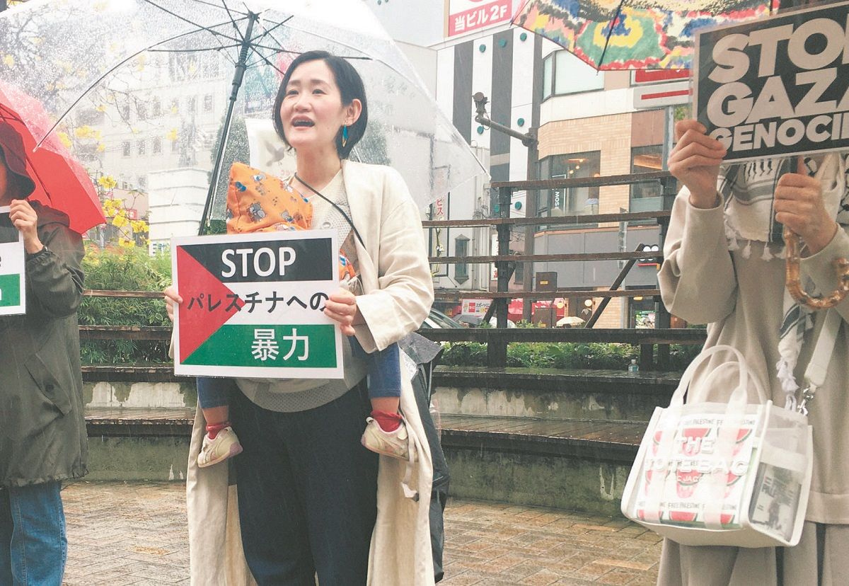 わが子とともに街頭に立ち、ガザ侵攻への反対を訴える疋田さん＝神戸市中央区で