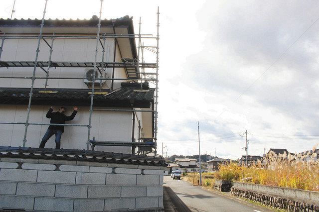 酒蔵にする民家（左）の隣は、草が生えたままの土地も広がっている＝福島県南相馬市小高区で