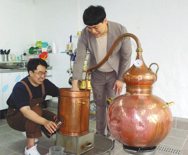 韓国・大田市で６月上旬、北朝鮮の方法で焼酎を蒸留する閔在明さん（左）と黄朱商さん